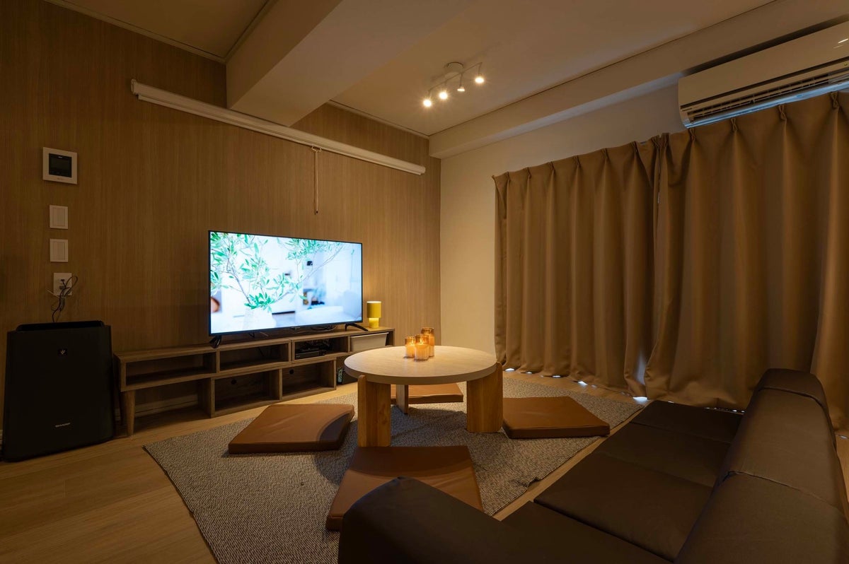 カーテンを閉めた夜のリビング。50型テレビの光とキャンドル風LEDランプの暖色が室内を照らし、昼間とはまったく違うムーディーな雰囲気に。映画鑑賞やゆったりとした時間にぴったり。